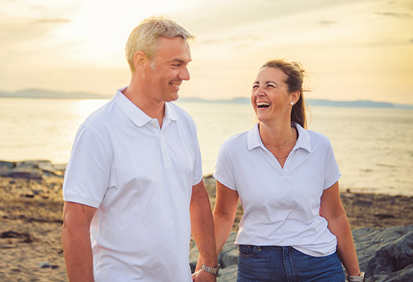couple walking and laughing on a beach